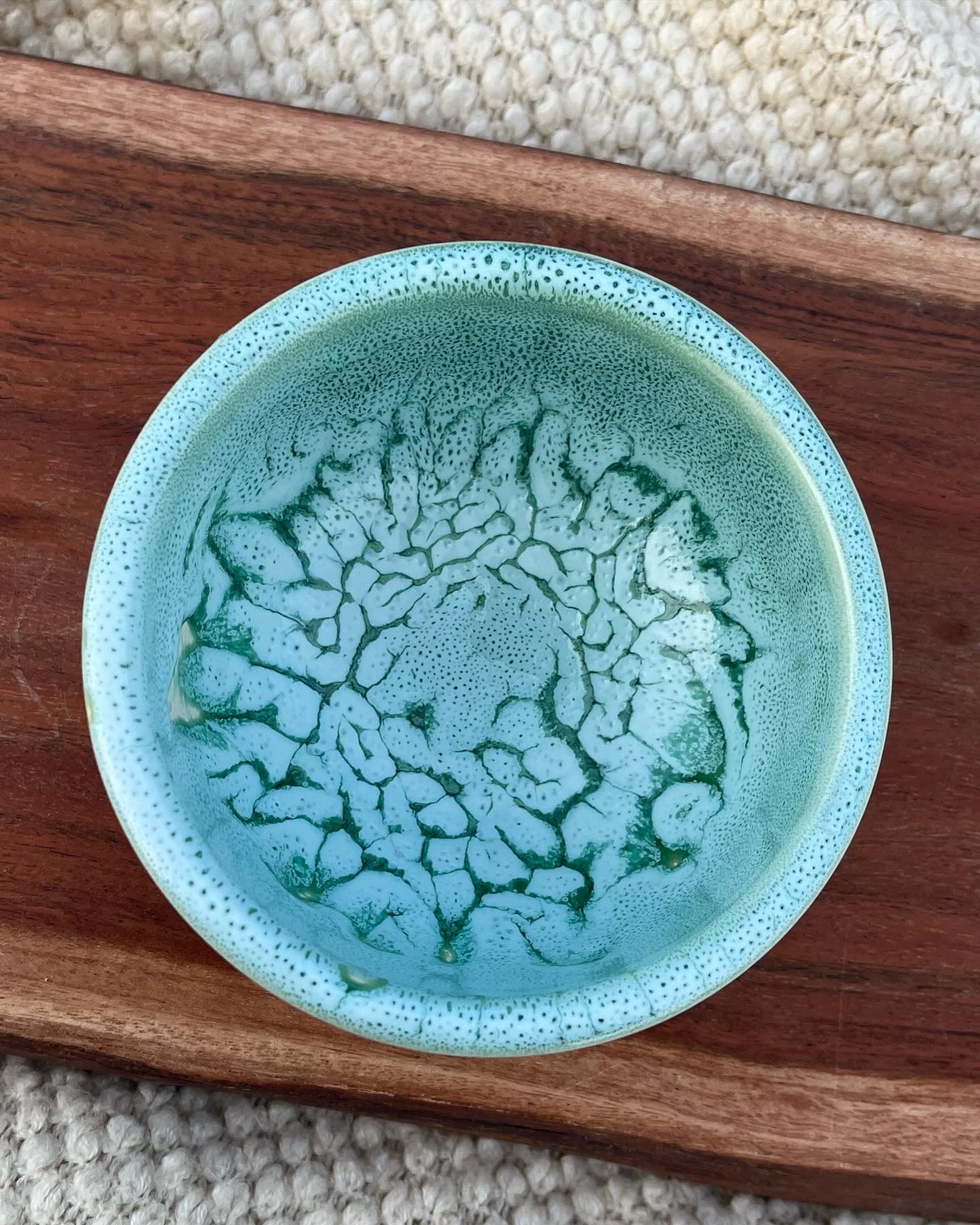 Close-up of a handmade bowl with a seafoam crackle glaze